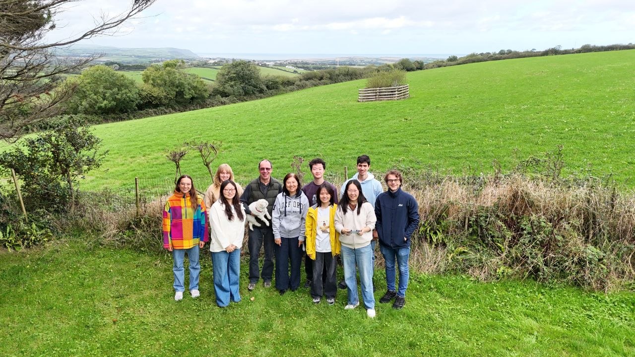 Group picture from drone, green hills and Cornwall coast on the background